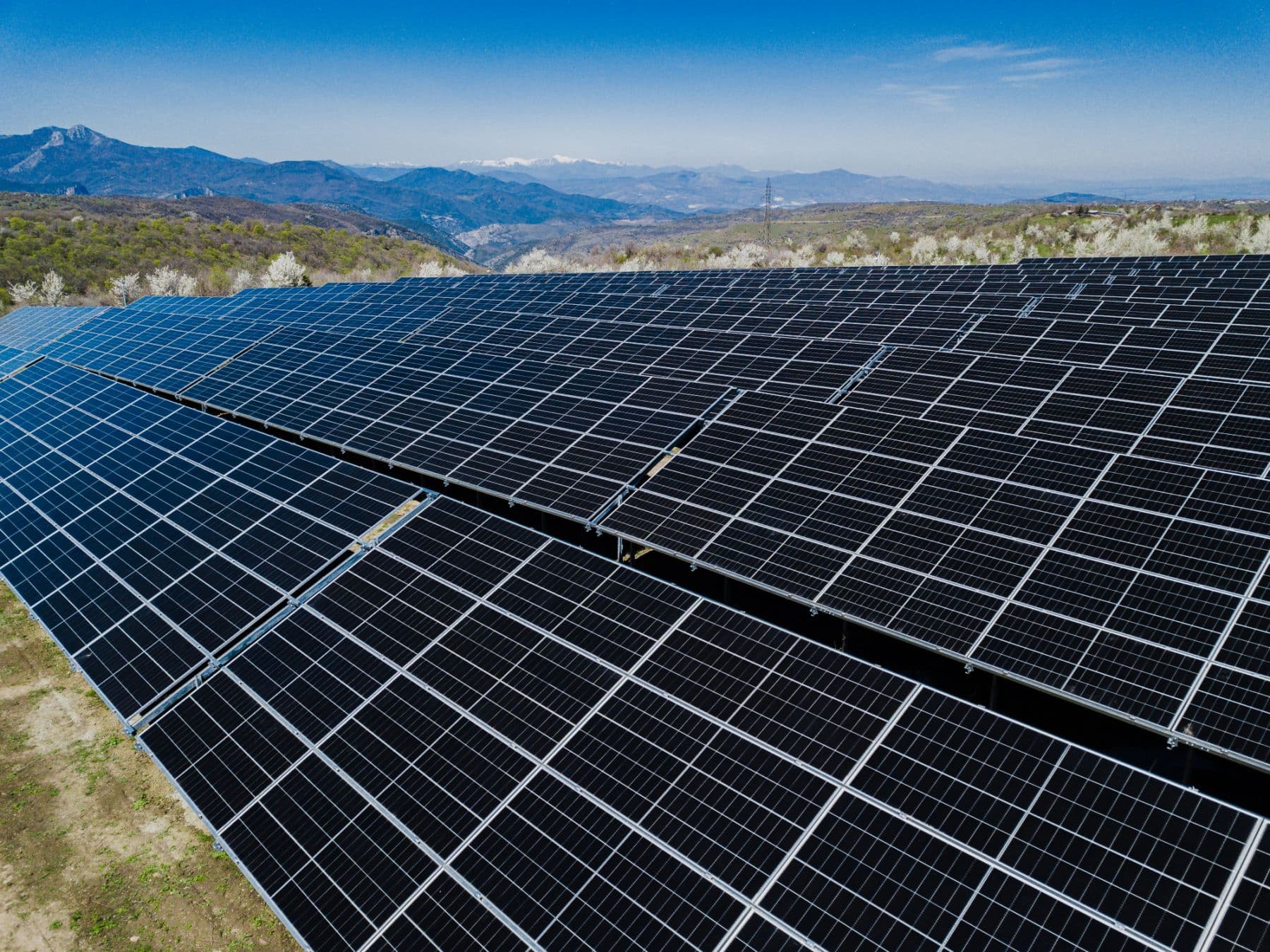 Completed ground-mount solar power plant with mountains in the background
